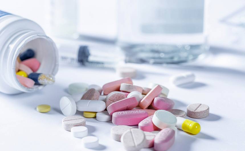 Ärztliches Behandlungsset mit Spritze und unterschiedlichen Medikamenten auf weißem Tisch